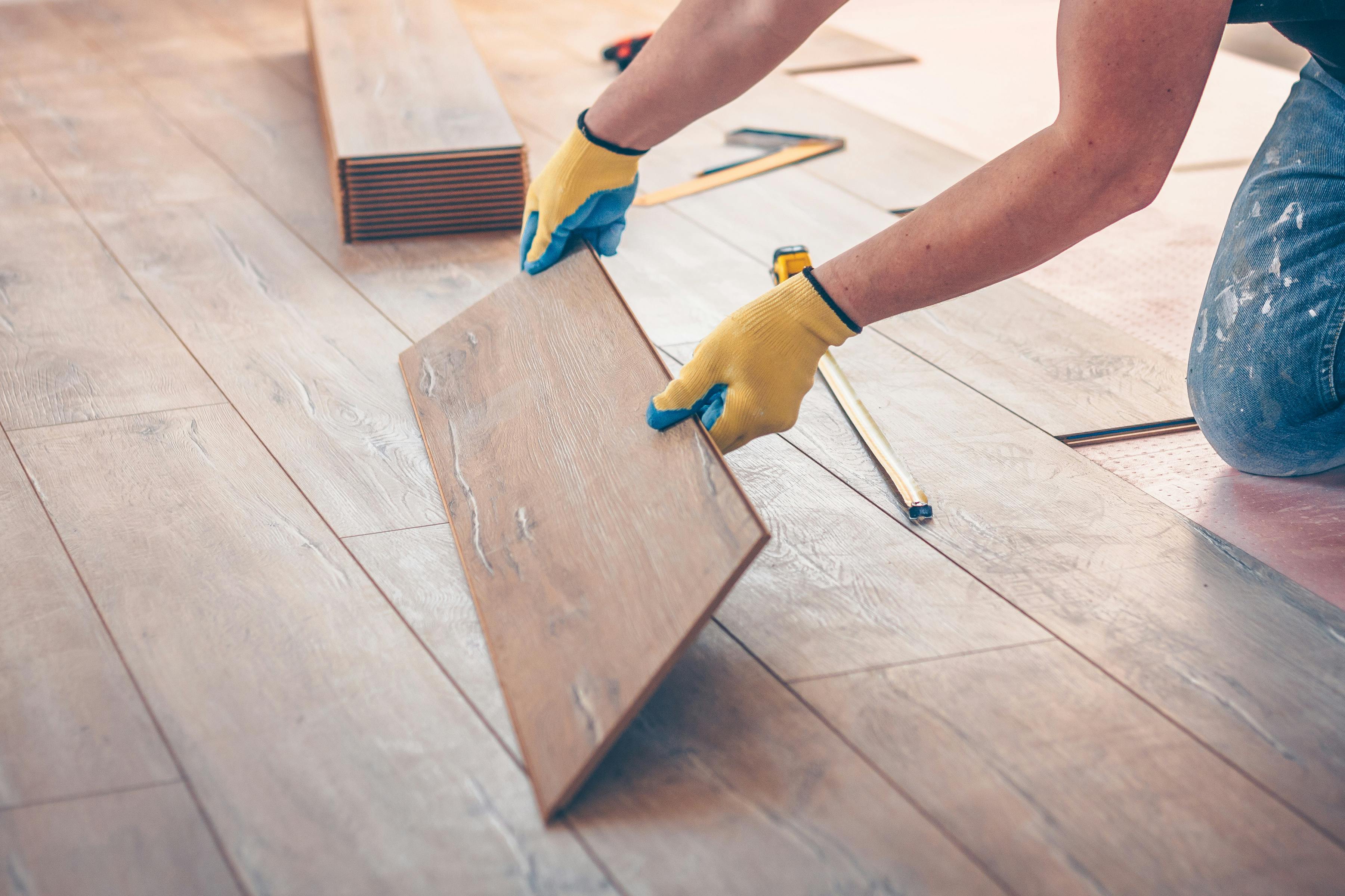 Stock image of someone laying a floor piece