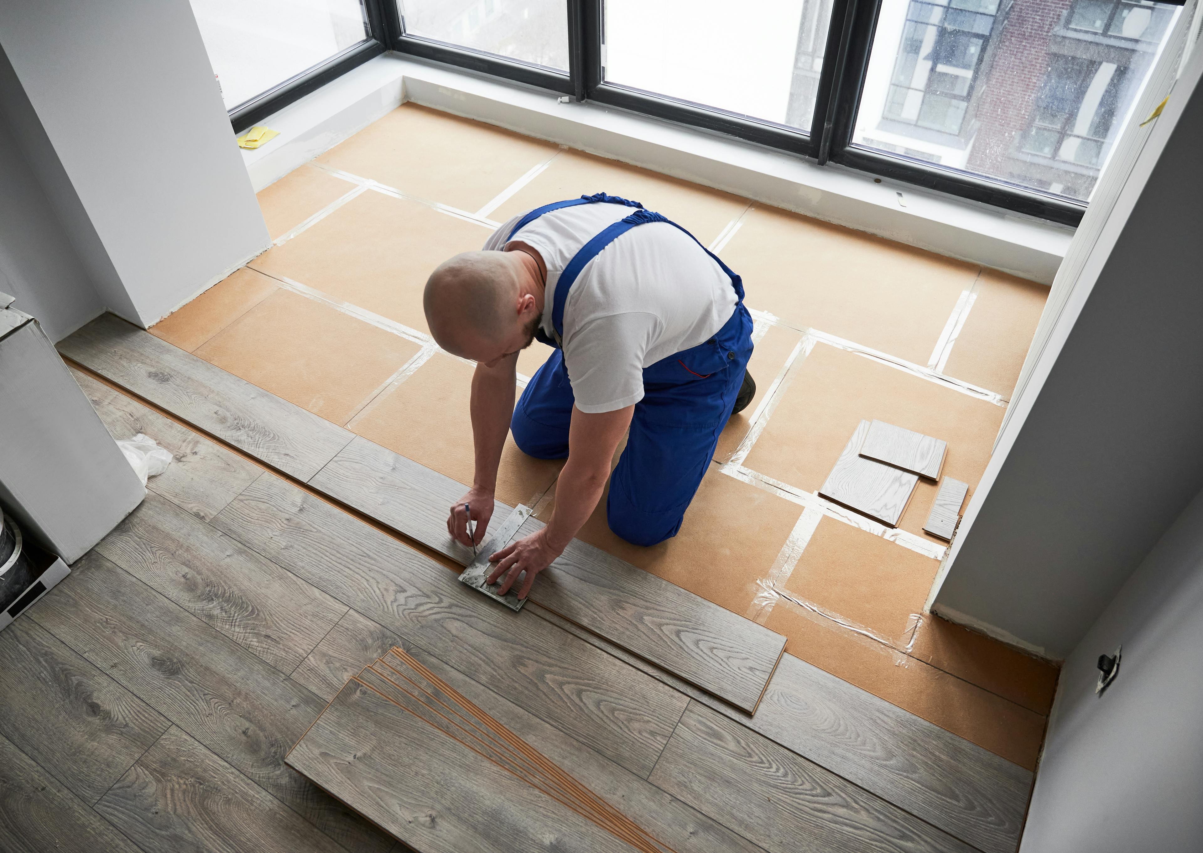 Stock image of a builder laying flooring